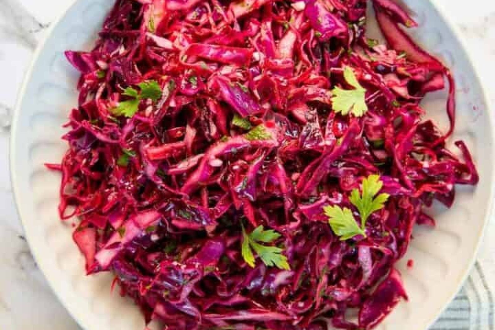Shredded red cabbage with parsley leaves on a white plate