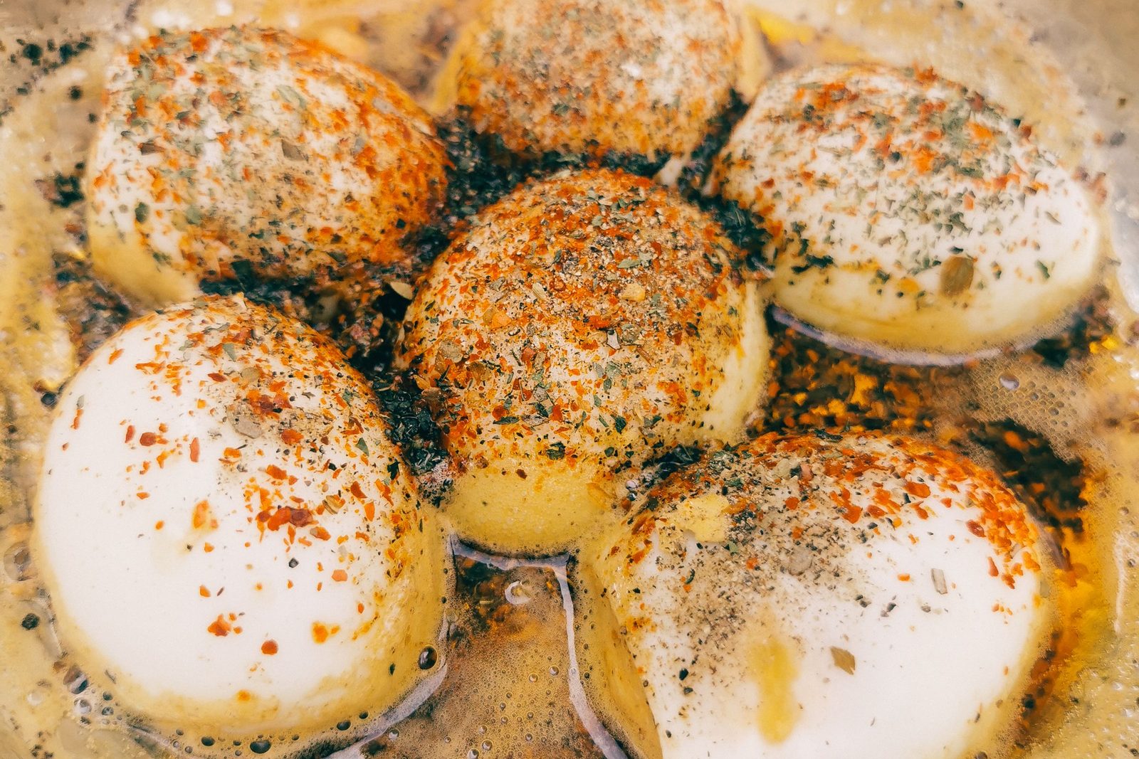 Spiced fried eggs in a pan