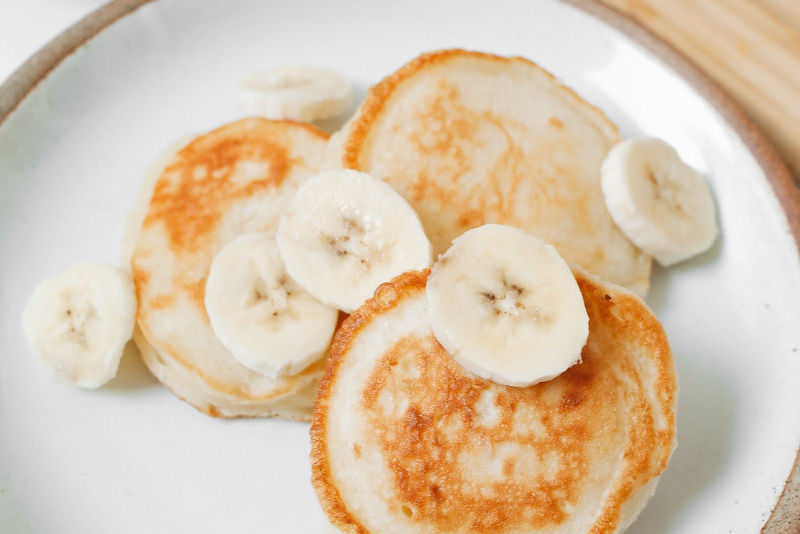Pancakes dorés garnis de rondelles de banane sur une assiette