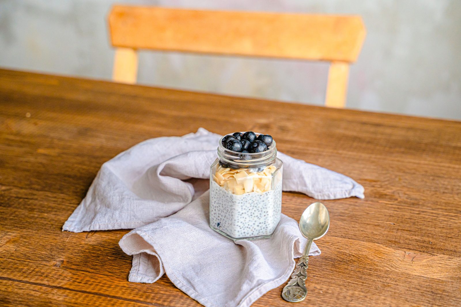 Pudding chia dans un bocal, garni de myrtilles et de noix de coco