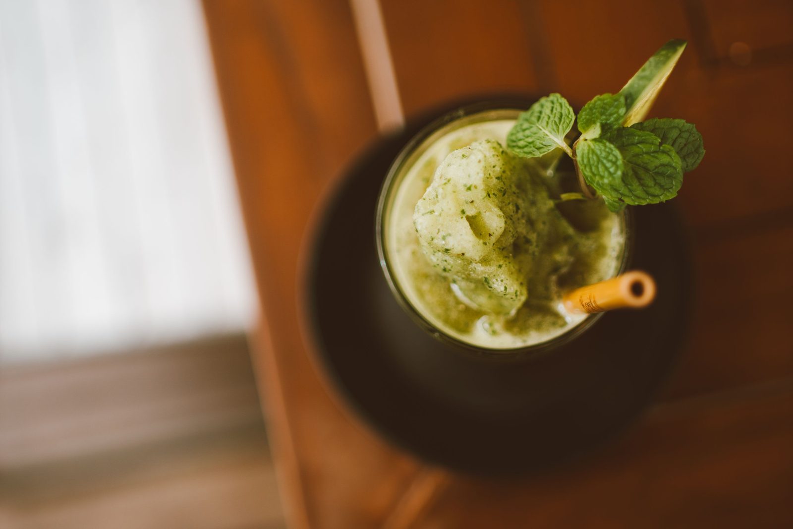 Smoothie vert dans un verre, garni de menthe, vu du dessus