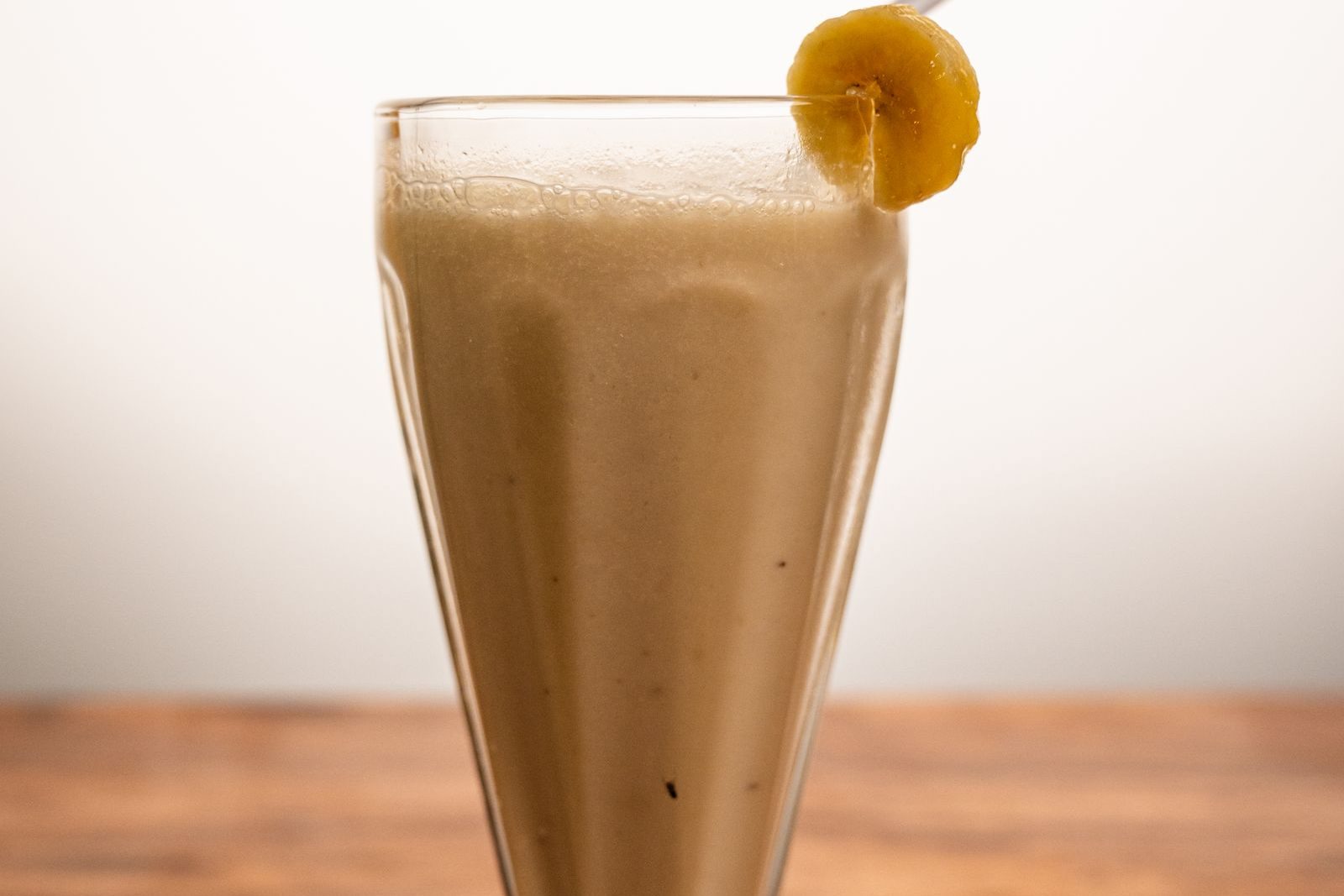 Smoothie à la banane dans un verre, rondelle de banane sur le bord