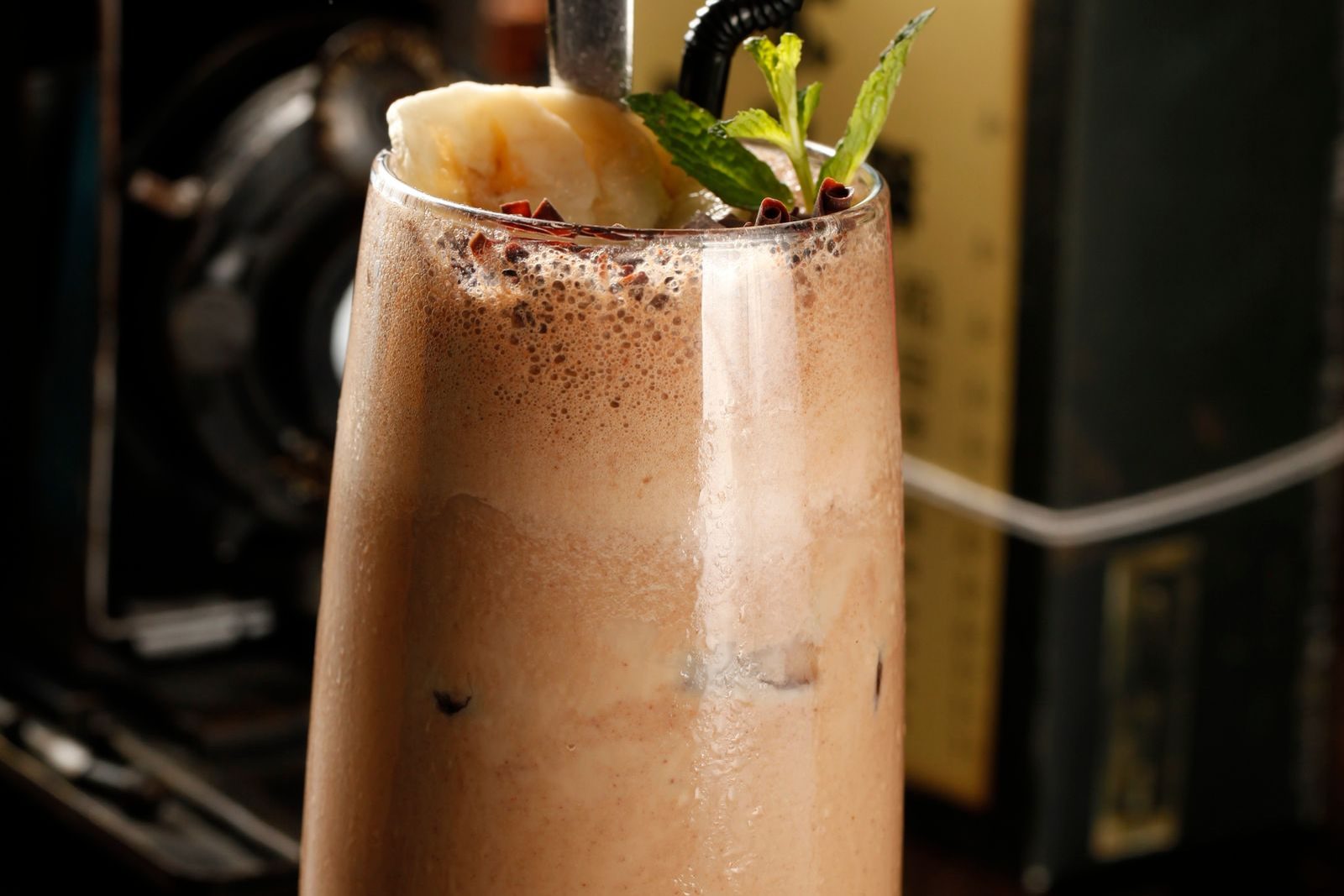 Smoothie de chocolate num copo alto com canudo preto